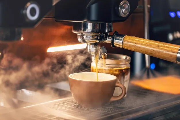 A close-up of an espresso shot being pulled from a coffee machine, the foundation for many types of coffee drinks